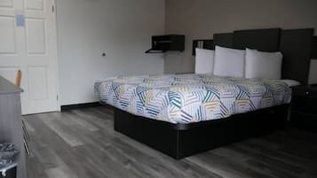 A hotel room with a bed, a desk, and a chair.