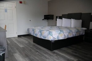 Una habitación de hotel con cama, escritorio y silla.