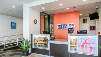 En hotellreception med en klocka, en digital display och en skylt som visar hotellets namn.