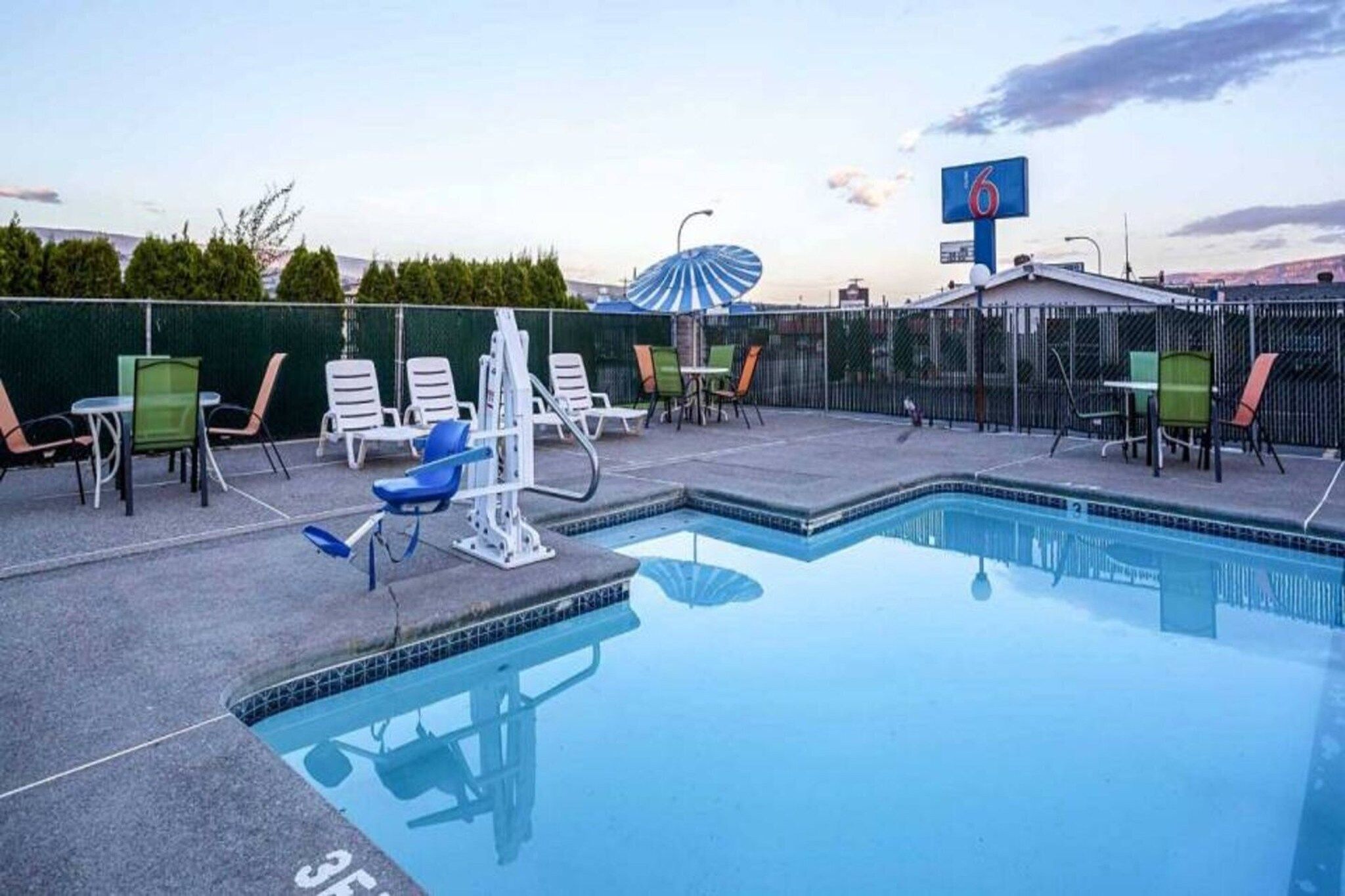 A swimming pool with lounge chairs and a fitness area.