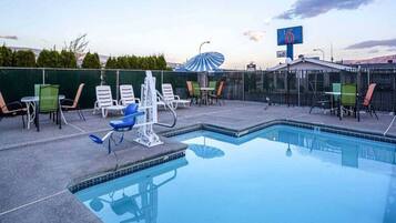 A swimming pool with lounge chairs and a fitness area.