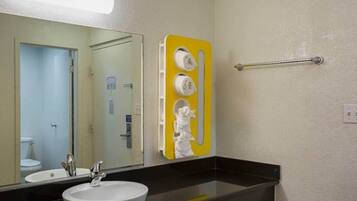 A bathroom with a sink, mirror, and towel rack.