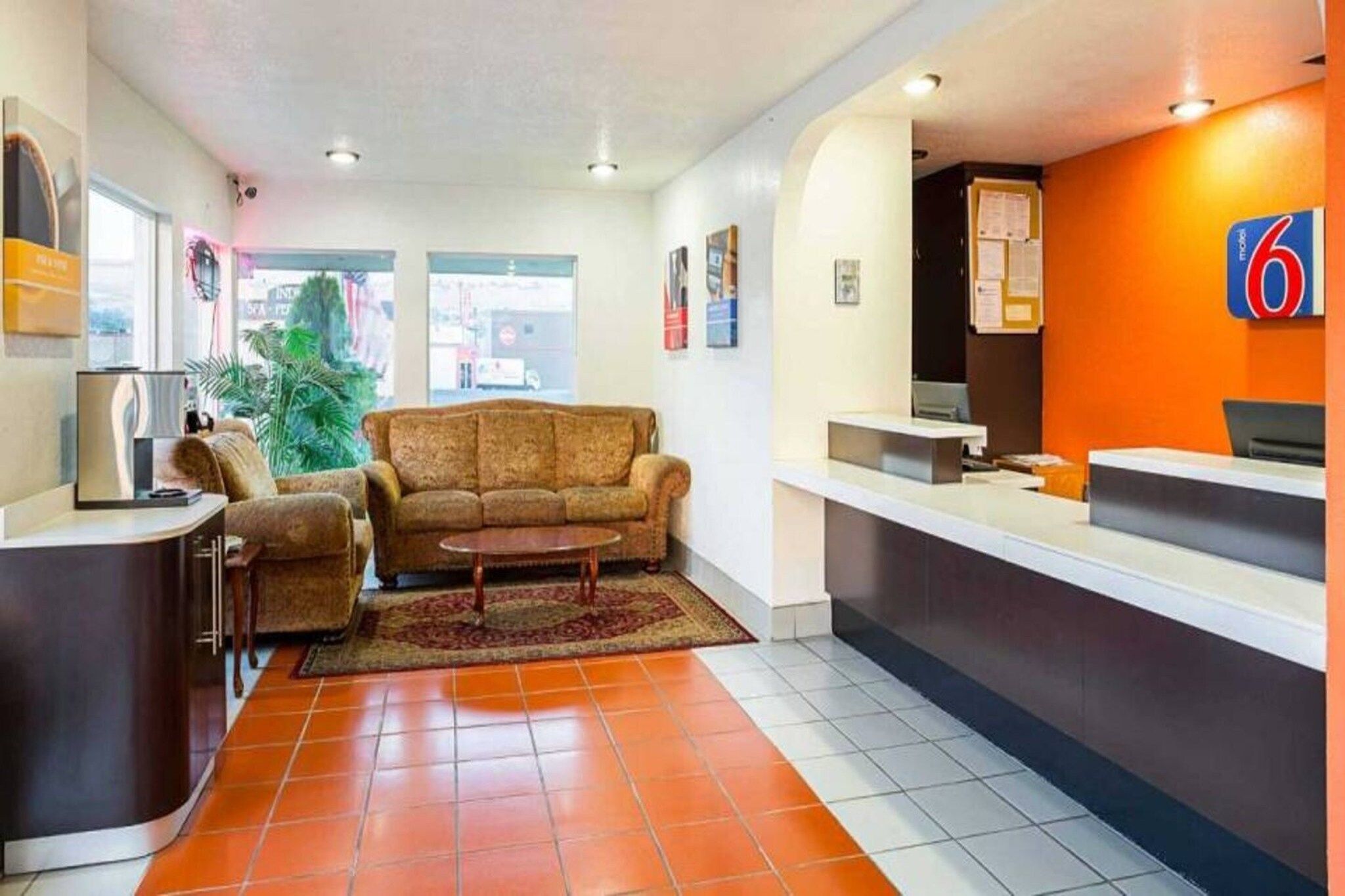 Una zona de recepción con un sofá, una mesita y un mostrador.