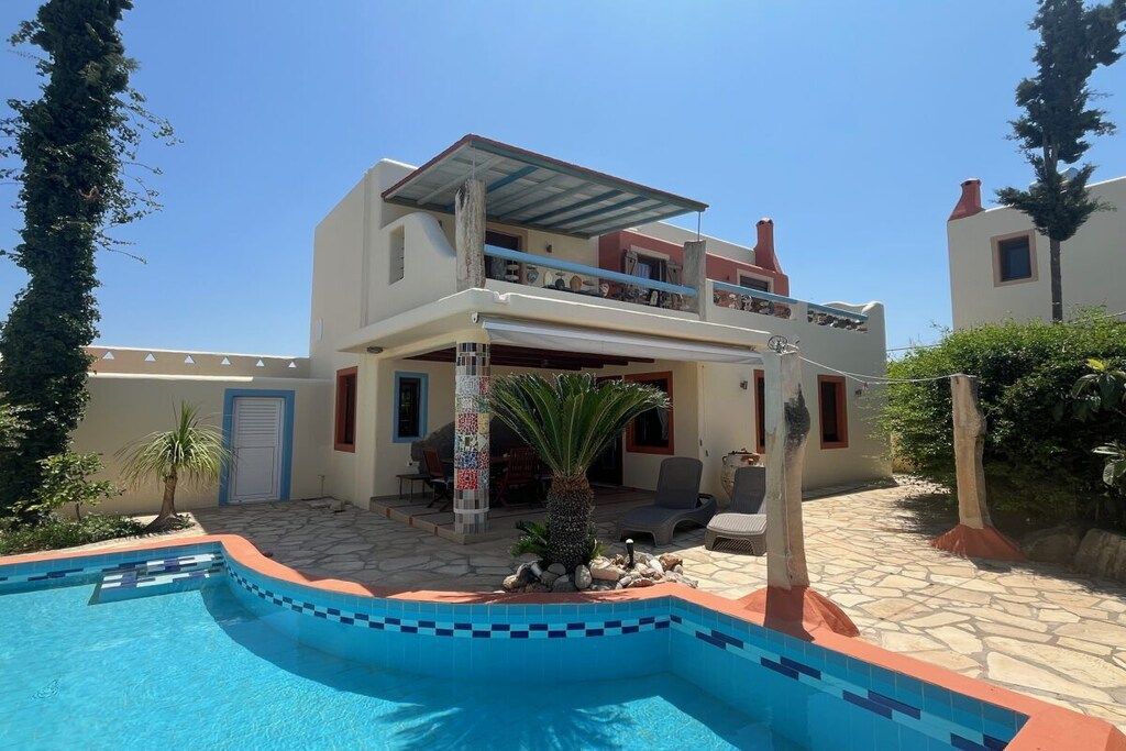Une maison à deux étages dotée d’une piscine, d’un espace extérieur aménagé et d’un patio couvert.