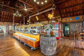 Un espacio interior amplio con techo de madera y una mesa de buffet.