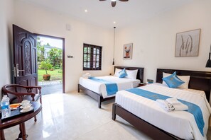 Habitación triple Deluxe, vistas al jardín | Colchones viscoelásticos, caja fuerte, escritorio y cortinas opacas