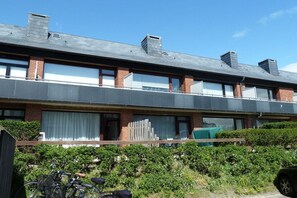A two-story residential building with a flat roof, brick facade, and large windows. - Holiday apartment with 1 bedroom (Westerland)