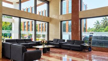 A spacious lobby with multiple seating areas, large windows, and a polished floor.