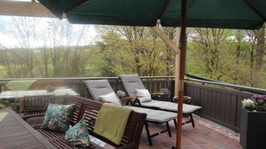 Une terrasse extérieure avec une table, des chaises et un espace abrité.