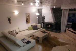 Een moderne woonkamer met een witte bank, een salontafel en een open haard.