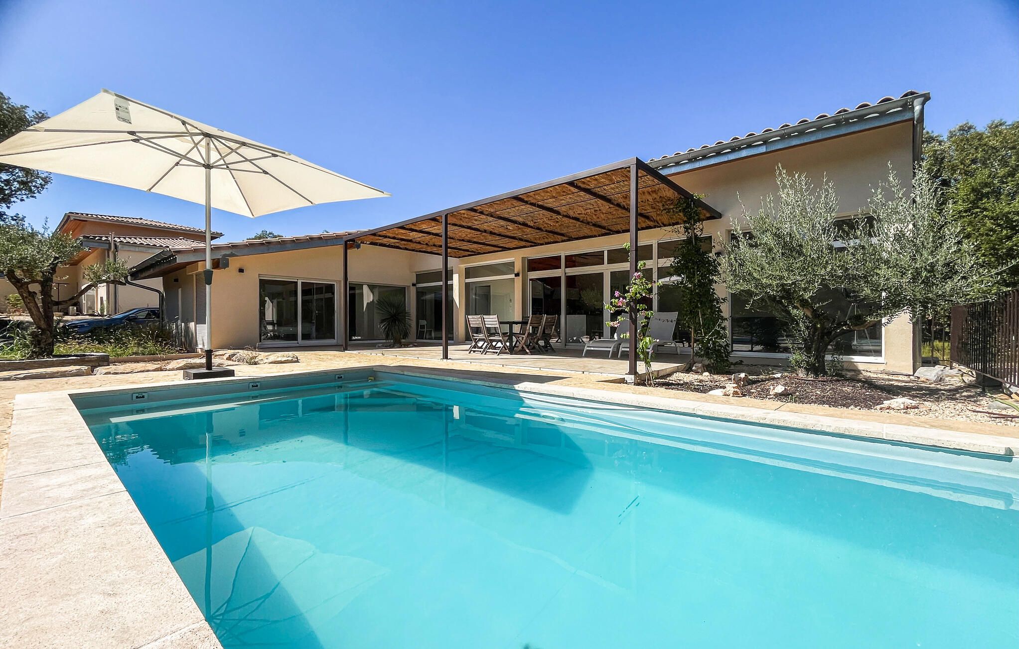 A swimming pool with a pergola and outdoor seating area.