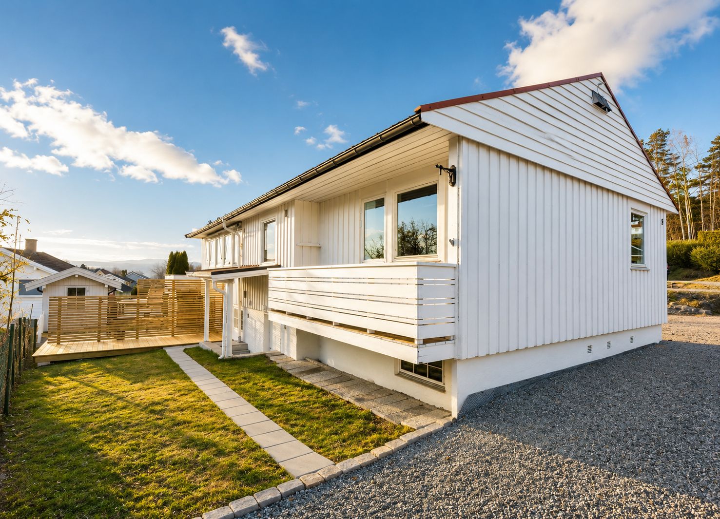 Une maison de plain-pied avec un porche à l’avant, une petite terrasse et une allée gravillonnée.