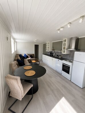 A modern kitchen with white cabinets, a black countertop, and a built-in oven.