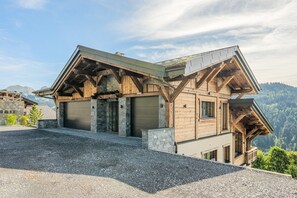 A chalet with a stone foundation, wooden beams, and a sloped roof. - Chalet Haute Cime - Les Gets - Les Cornuts (Les Gets)