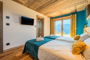 A hotel room with two beds, a TV, a shower, and a view of the outdoors. - Chalet Haute Cime - Les Gets - Les Cornuts (Les Gets)
