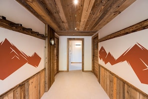 A hallway with wooden paneling and a carpeted floor, leading to a door. - Chalet Haute Cime - Les Gets - Les Cornuts (Les Gets)