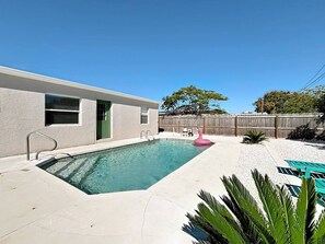 Ein rechteckiger Swimmingpool mit einer Metallleiter, umgeben von einer Betonplattform.