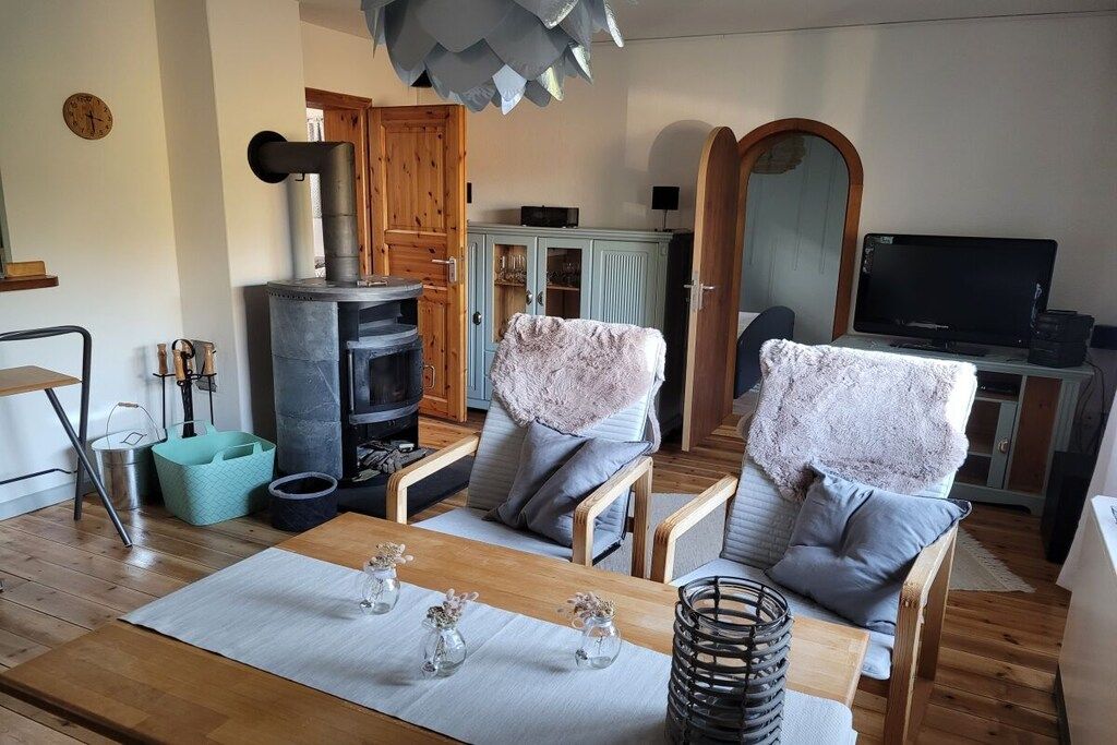 Una sala de estar acogedora con chimenea, muebles de madera y un televisor.