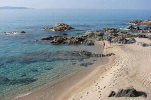 A beach with clear water, rocky outcrops, and footprints. - Holiday home with 2 bedrooms (OLMETO PLAGE)