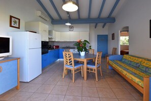 A compact kitchen with a dining area, a sofa, and a television. - Holiday home with 2 bedrooms (OLMETO PLAGE)