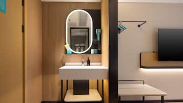 A modern bathroom with a vanity, a mirror with lighting, a towel rack, and a flat-screen TV mounted on the wall.