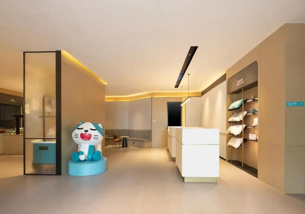 A modern hotel lobby with a minimalist design, a seating area, and a display of pillows.