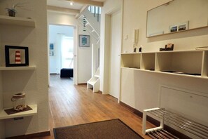 A hallway with wooden flooring, white walls, and a staircase leading to another room. - Holiday apartment with 1 bedroom (Krummhörn \/ OT Greetsiel)