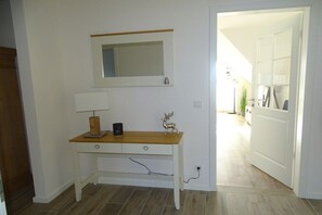 A room with a white desk, a lamp, a mirror, and a decorative deer figurine. - Holiday apartment with 1 bedroom (Seedorf)