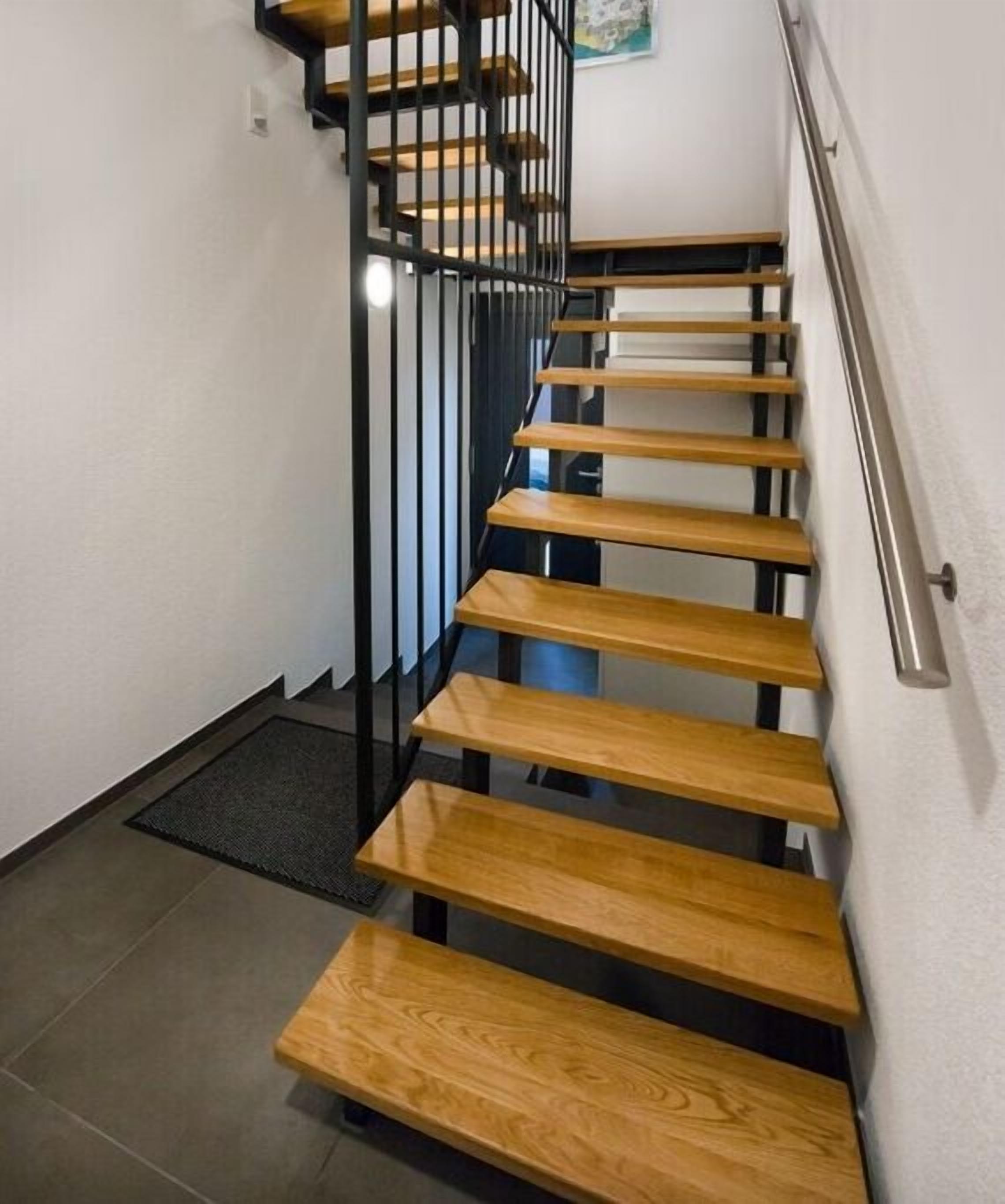 A staircase with wooden steps and black metal railings.