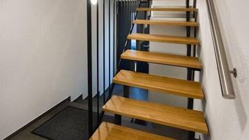 A staircase with wooden steps and black metal railings.