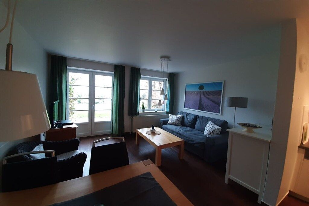 Ein Wohnzimmer mit einer Couch, einem Couchtisch, einer Lampe und einem Bild an der Wand.