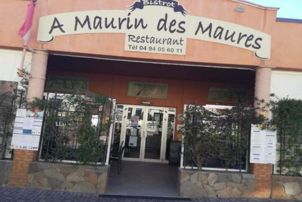 The exterior of a restaurant named 'A Maurin des Mares' with a stone facade and a signboard above the entrance.