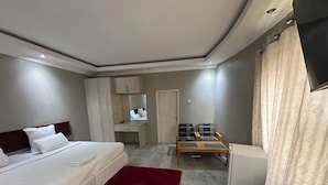 Ein Hotelzimmer mit einem Bett, einem Schreibtisch, einem Stuhl, einem Spiegel und einem Kleiderschrank.