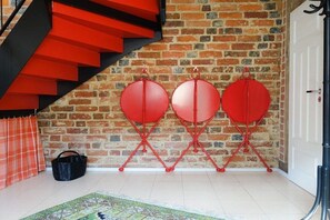 A staircase with red steps, a brick wall, and three red folding chairs against the wall. - Holiday home in Tangermünde with Wi-Fi (Tangermünde)