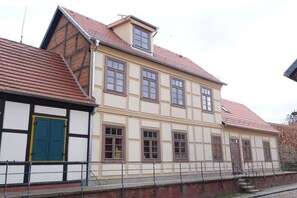 Un bâtiment à deux étages, doté d’un toit à pignon et de nombreuses fenêtres.