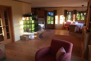 A spacious living room with a red armchair, a wooden coffee table, and a green cabinet. - Holiday home with 1 bedroom (Altaussee)