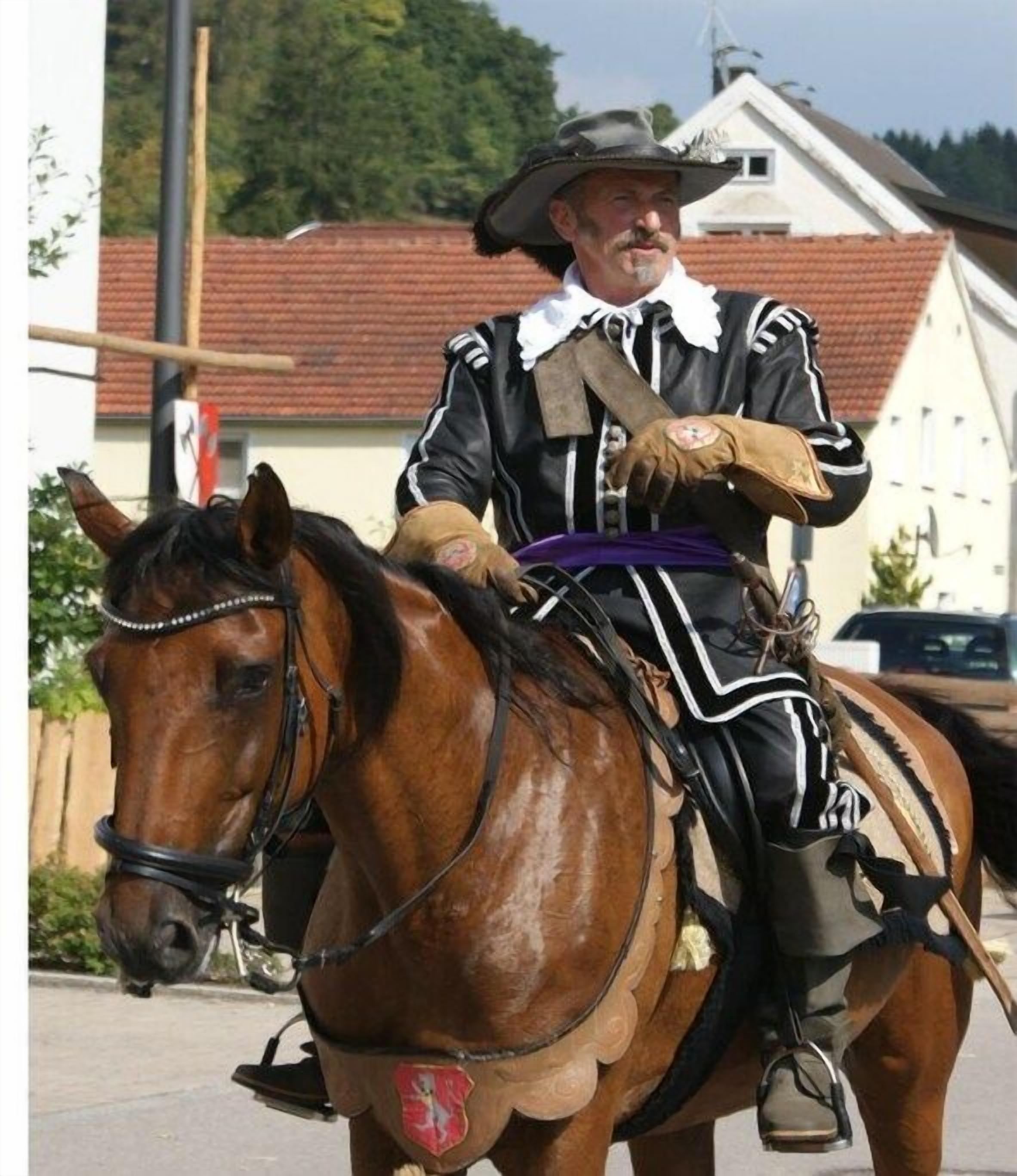A person in historical costume riding a horse.
