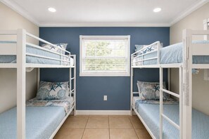 A room with bunk beds, a window, and a tiled floor. - Siesta Sands Paradise 4BR 3BA Sleep 16 (Sarasota)
