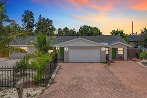 A residential property with a garage, paved driveway, and a fenced yard. - Siesta Sands Paradise 4BR 3BA Sleep 16 (Sarasota)