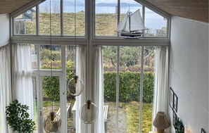 A room with large windows, a sailboat model, and hanging light fixtures. - Awesome home in Bjoa with WiFi (Bjoa)