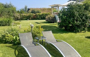 A garden with two lounge chairs, a pergola, and various plants. - Awesome home in Bjoa with WiFi (Bjoa)