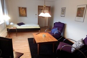 A room with a bed, a chair, a table, and artwork on the walls. - Just outside Hamburg 4 (Reinbek)