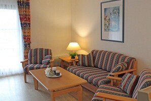A living room with a sofa set, a coffee table, and a lamp. - Holiday home in Allgäu with 1 bedroom (Lechbruck)