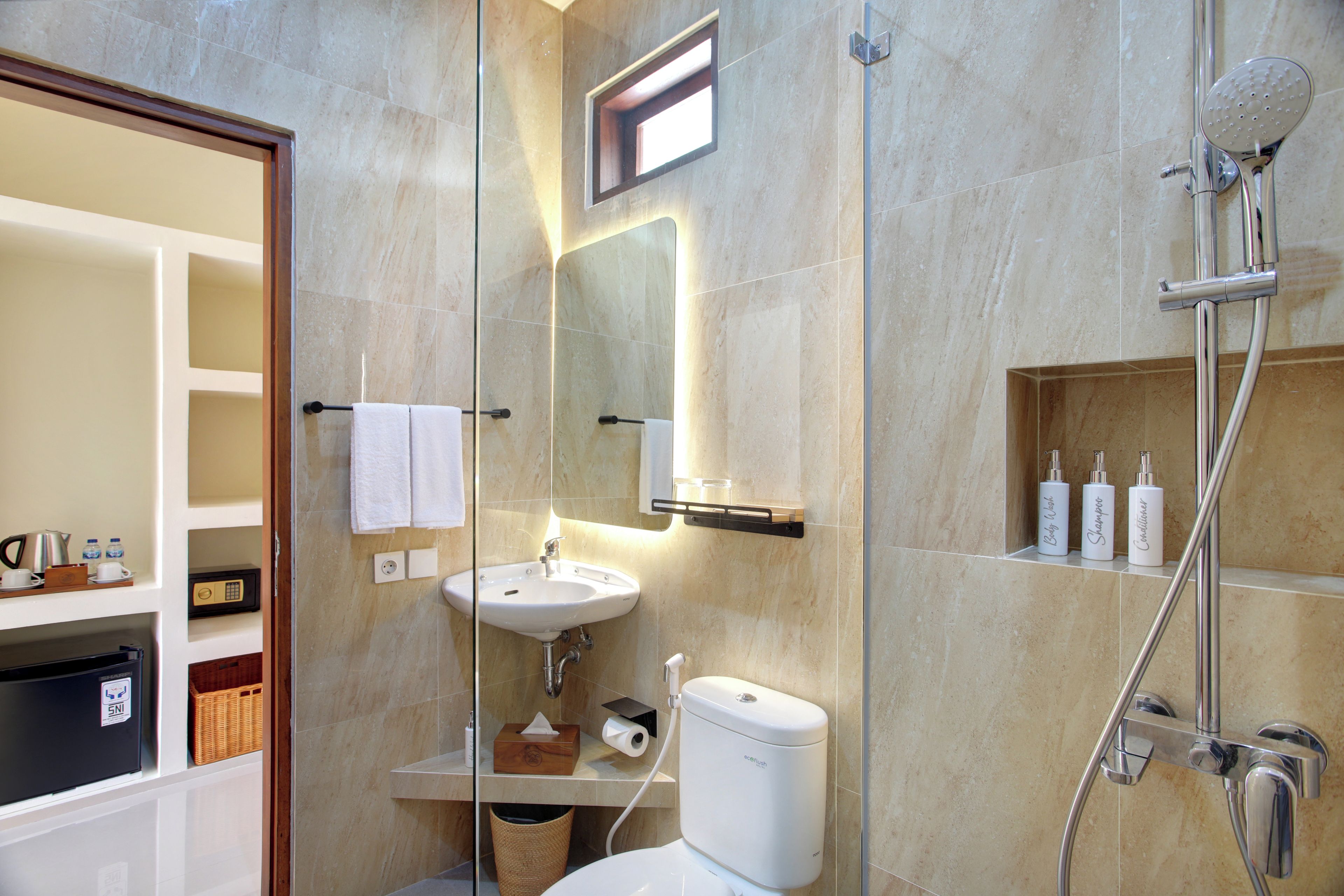 Une salle de bain moderne avec une douche à parois de verre, un lavabo et des articles de toilette.