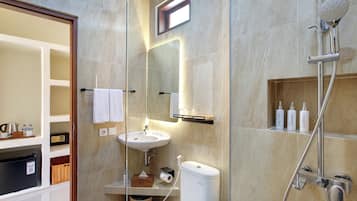 Une salle de bain moderne avec une douche à parois de verre, un lavabo et des articles de toilette.