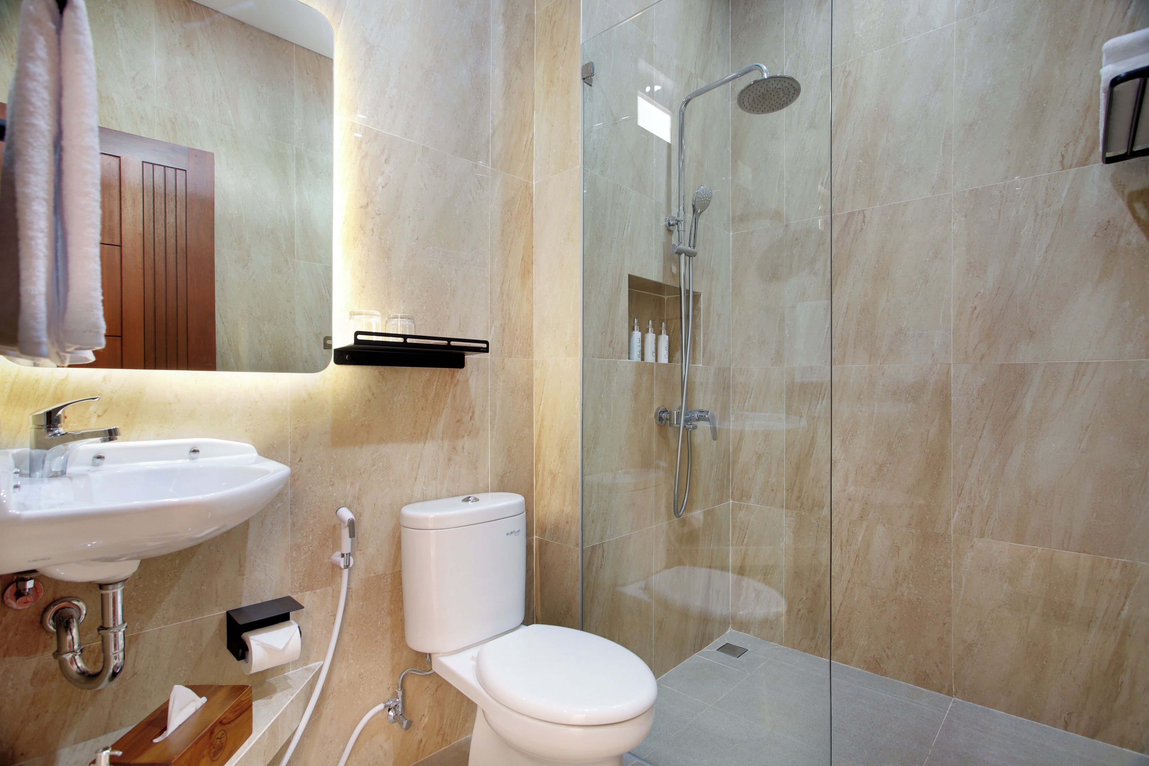 Een moderne badkamer met toilet, wastafel en douche.