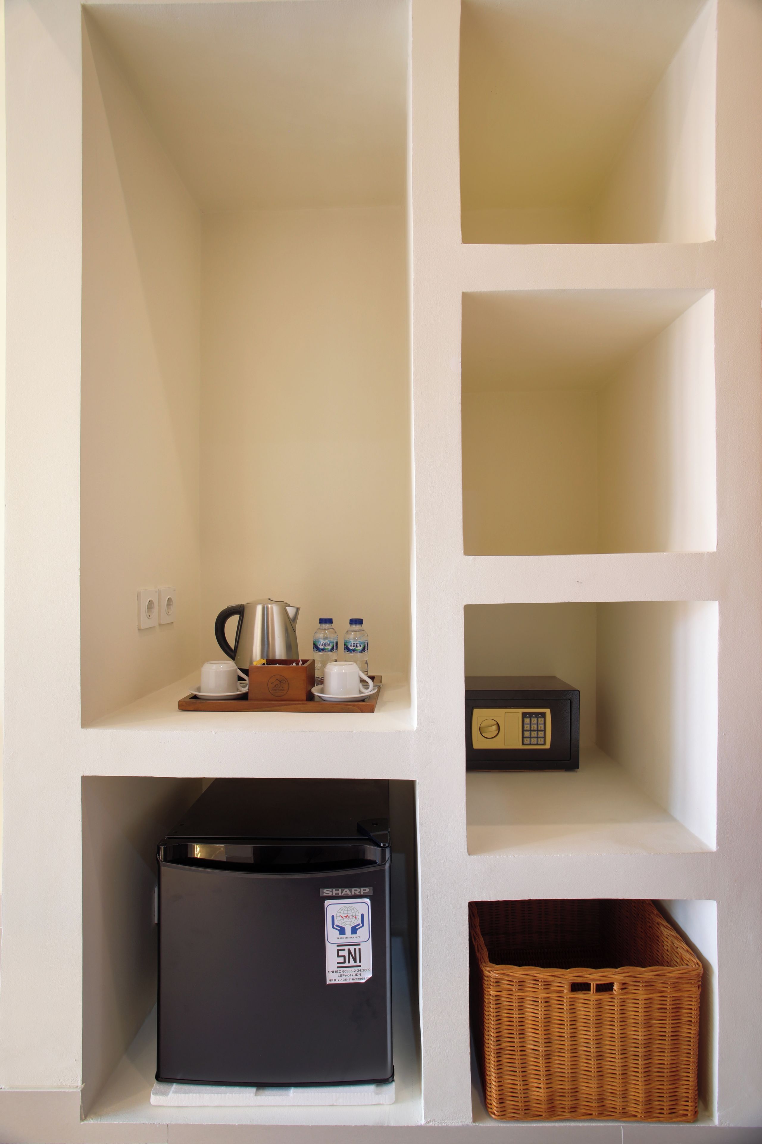 Una kitchenette con cafetera, botellas de agua y microondas.