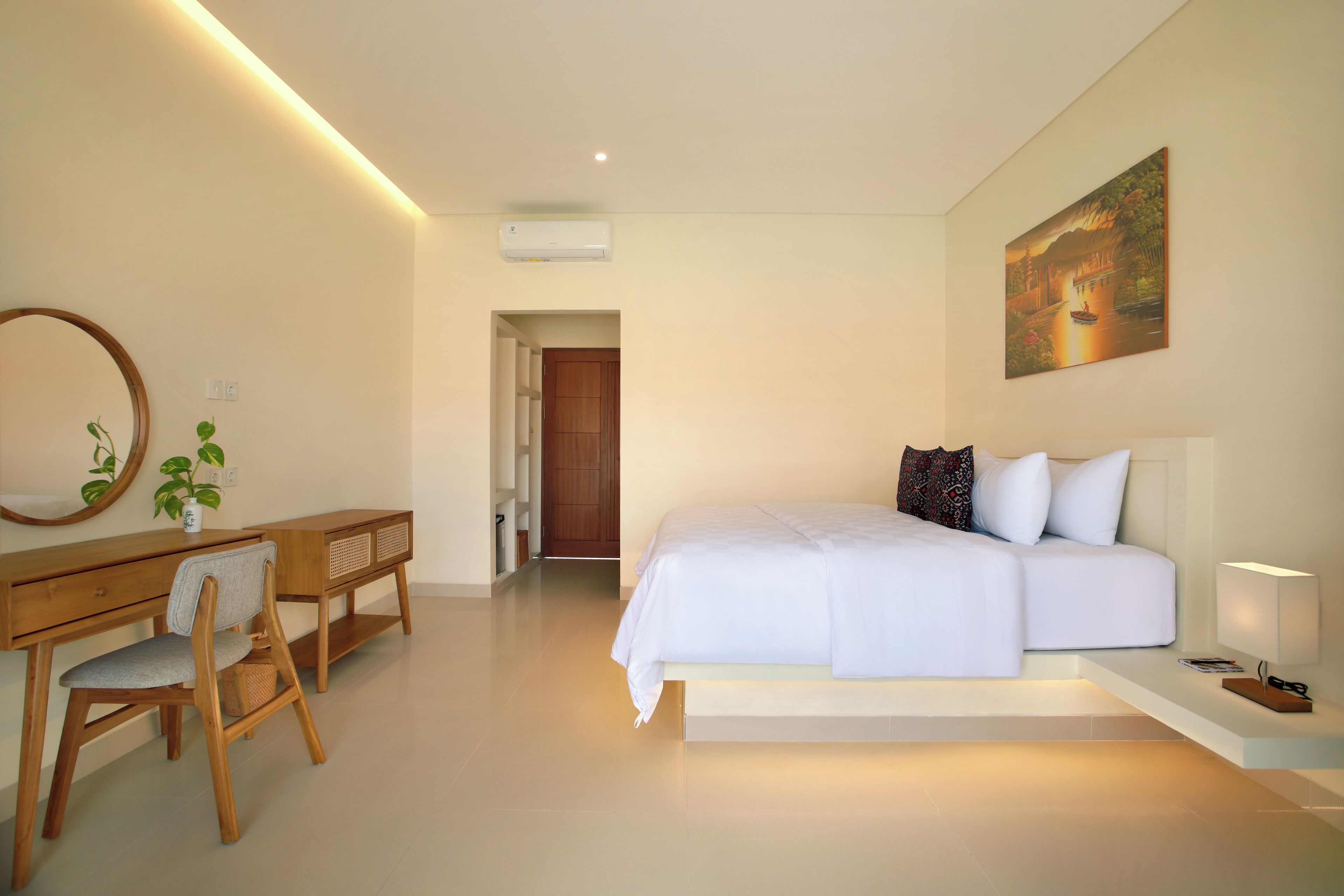 Un dormitorio con cama, mesita de noche, lámpara y un cuadro en la pared.