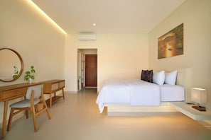 A bedroom with a bed, bedside table, lamp, and a painting on the wall.