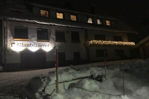 Een gebouw met een bord waarop 'Glasbläserrei' staat, en een met sneeuw bedekte grond.